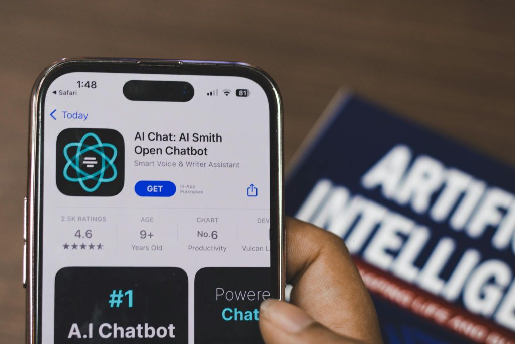 The Essentials of Blogging: Tips and Strategies for Success Hand holding a smartphone with AI chatbot app, emphasizing artificial intelligence and technology.